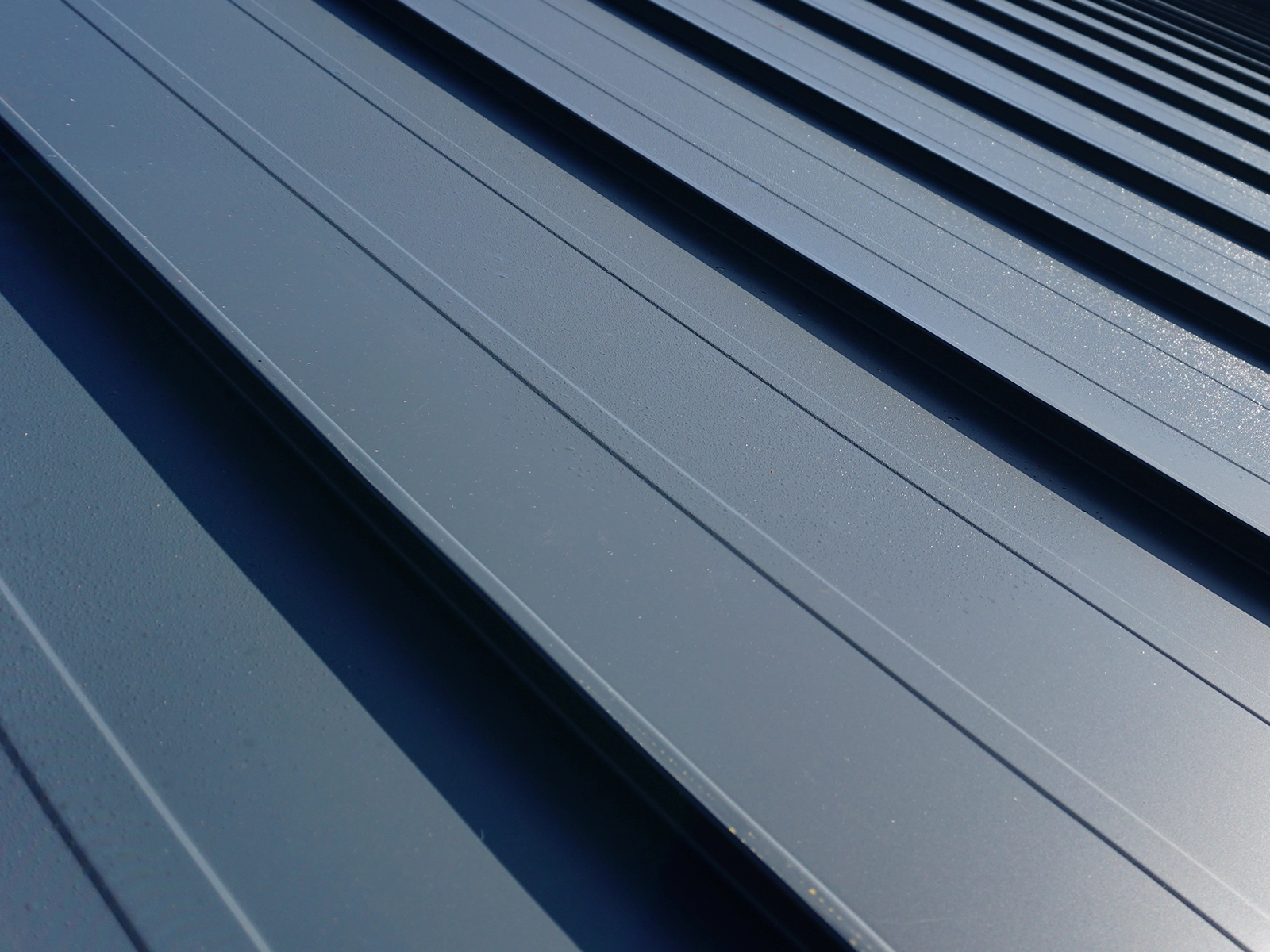Heavy-gauge aluminum standing seam metal roofing with a low-porosity surface, showcasing durability and resistance to moss and algae growth, ideal for all-season stability in Burnaby, BC.